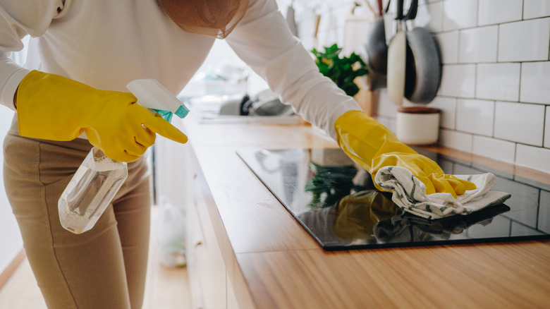 Person cleaning a glass stovetop