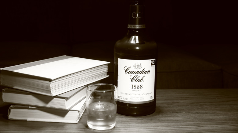 Canadian Club whisky next to books