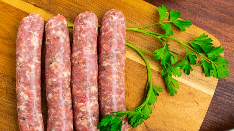 four sausages on cutting board