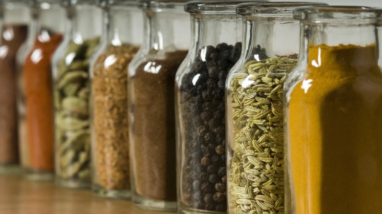 Various whole and ground spices in glass jars