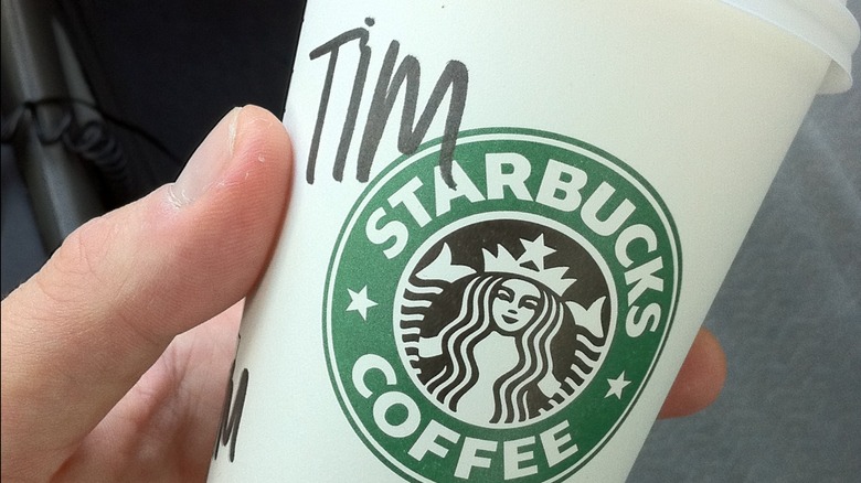 Starbucks barista pouring drink into cup