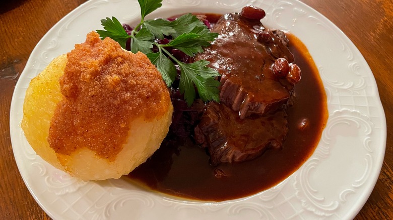 A plate of sauerbraten with potato dumplings