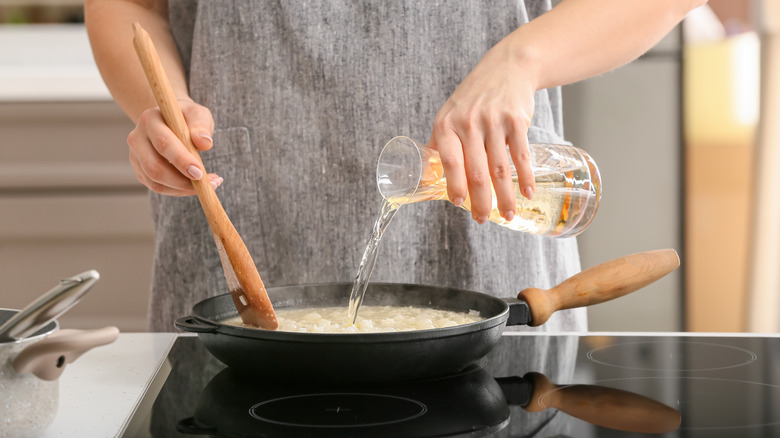 chef pouring water in risotto