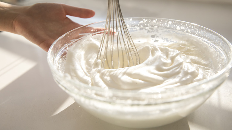 A whisk whipping cream in a bowl