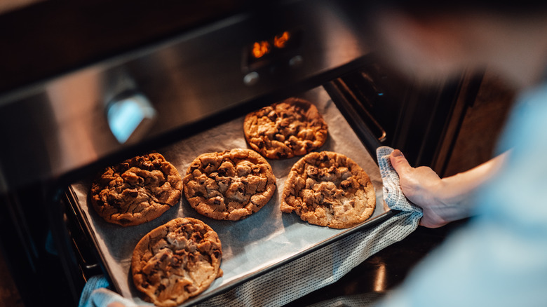 Person putting a tray of cookies into the oven