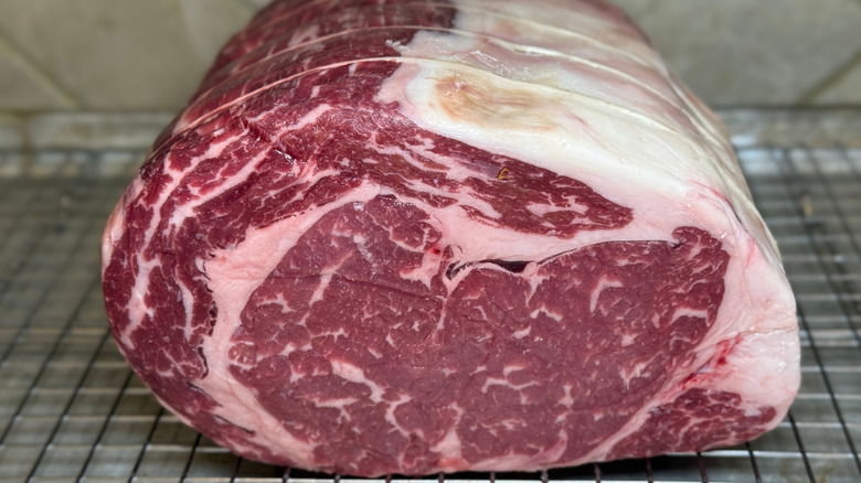 Raw prime rib on a roast grate