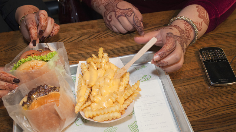 hands reach for Shake Shack fries