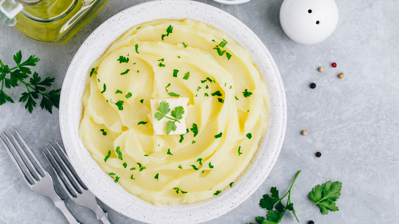 Mashed potatoes in bowl with herbs