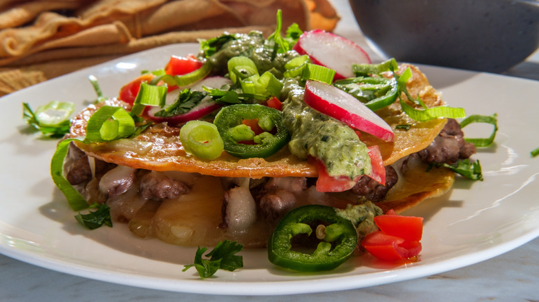 Mulitas with steak topped with guacamole