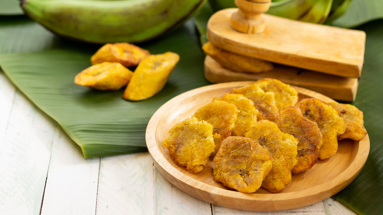 Tostones with a tostonera in the background