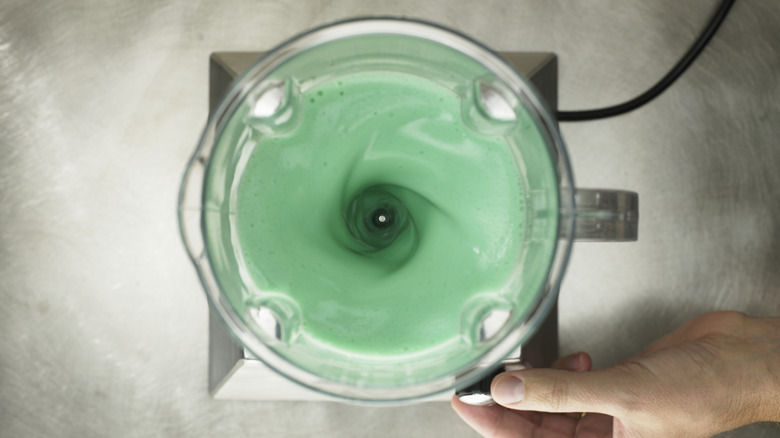 Food processor filled with green liquid
