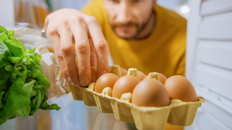 man taking an egg from fridge