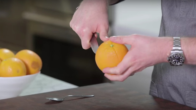 Scoring an orange peel with a knife