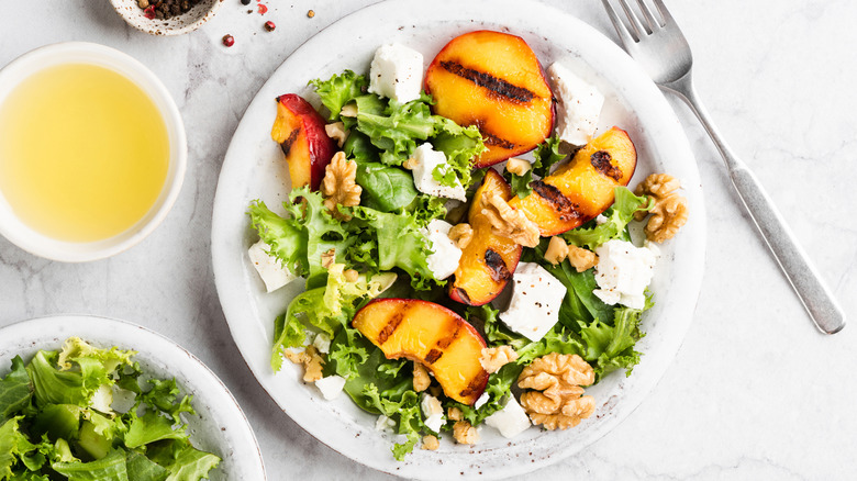 Salad with grilled peaches, walnuts, and cheese