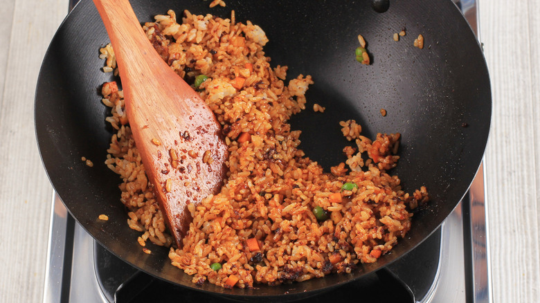 pushing fried rice to one side of wok