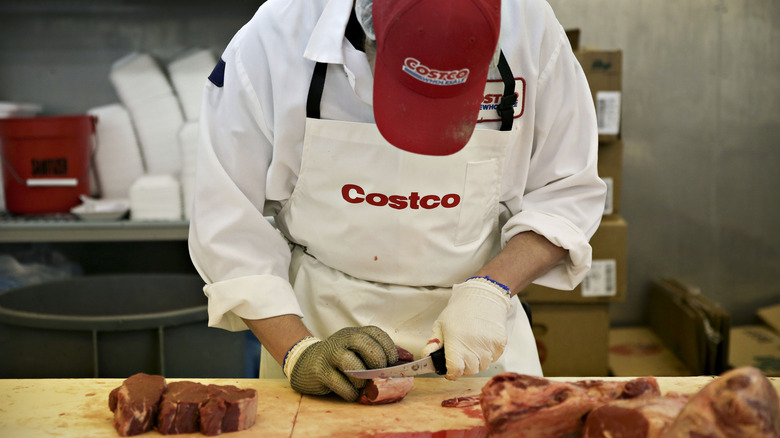 Costco butcher cutting meat.
