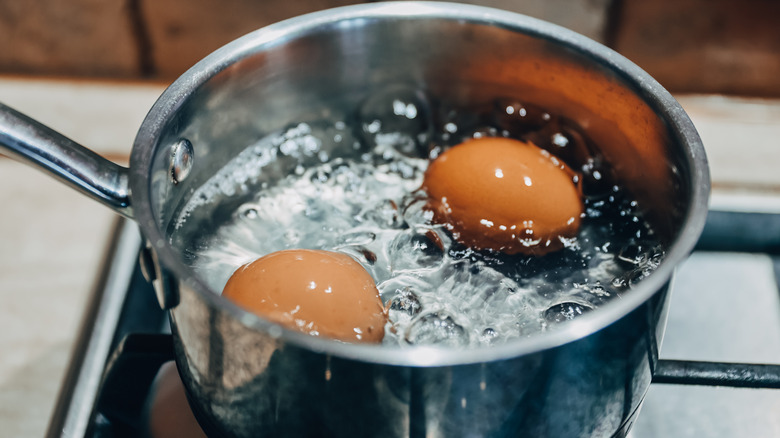 Saucepan with boiling eggs on stove