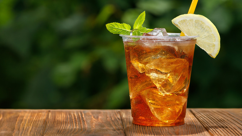 A glass of iced tea with a lime and mint garnish