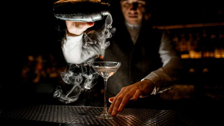 bartender pouring smoky drink