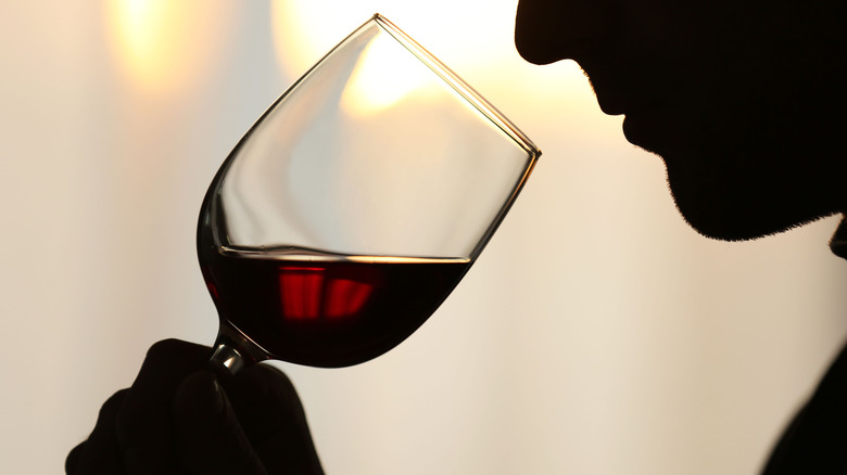 Silhouette of man smelling red wine