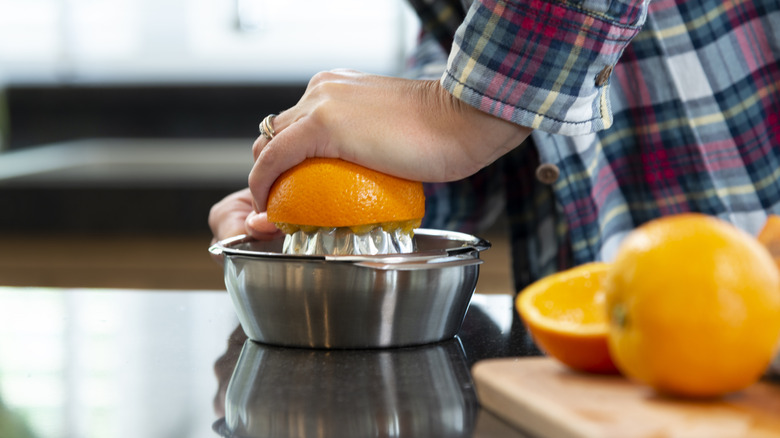 Squeezing oranges on a juicer