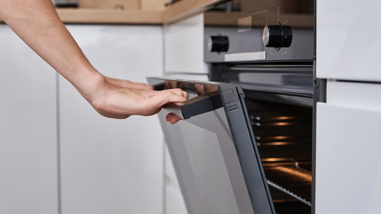 Hand closing an oven door