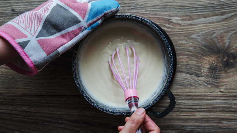 Person whisking bechamel sauce