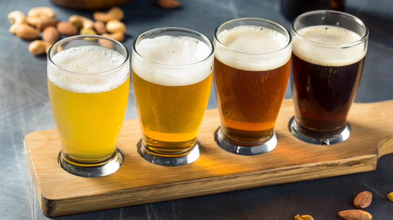 Four-glass beer flight on a wooden paddle