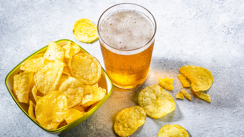 bowl of potato chips and pint of pilsner beer