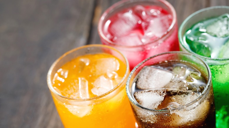 variety of sodas in glasses with ice