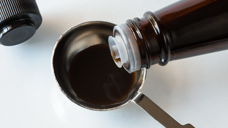 Worcestershire sauce pouring into teaspoon