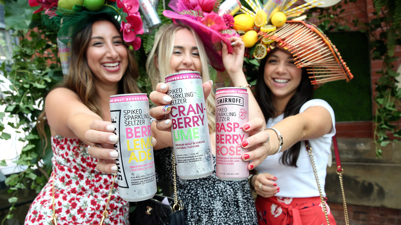 three woman holding Smirnoff seltzers