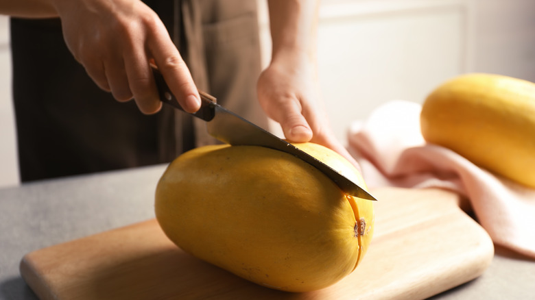 woman cutting squash with knife