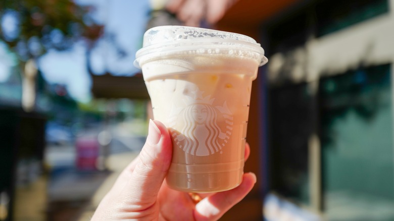 iced Starbucks chai drink held outside