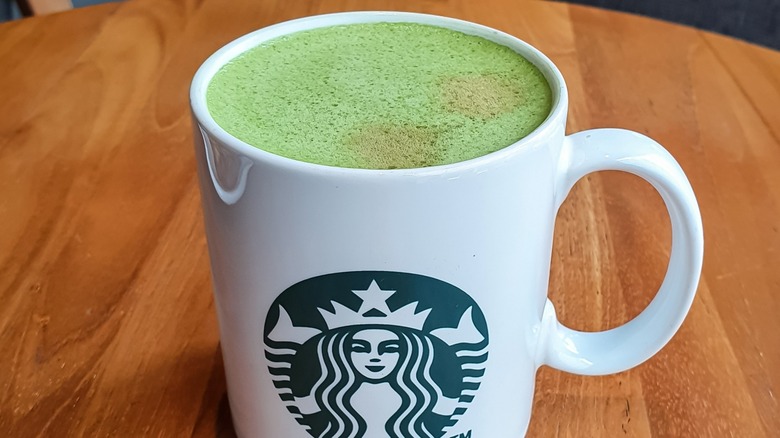 A hot, foamy Starbucks Matcha Latte in a branded mug