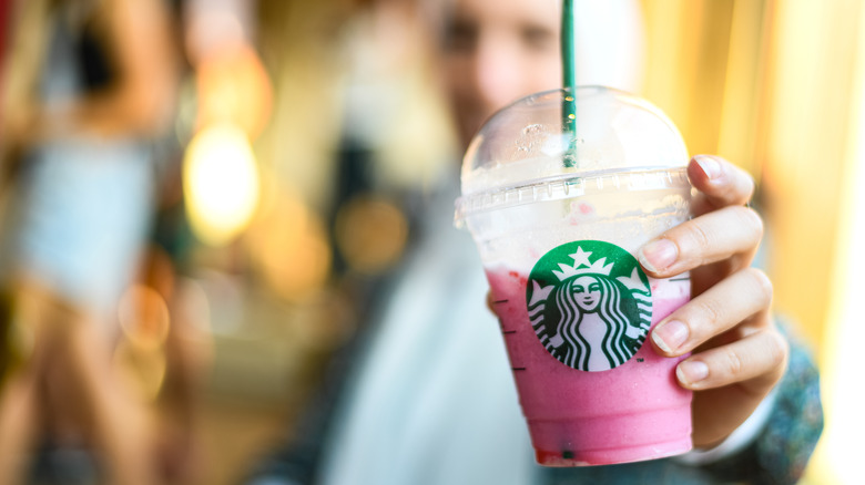 woman holds starbucks passion tea