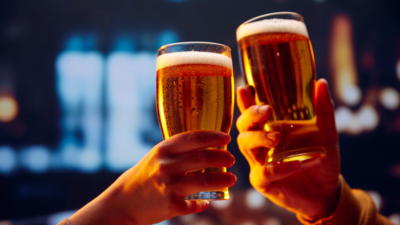 Two hands with beer toasting glasses