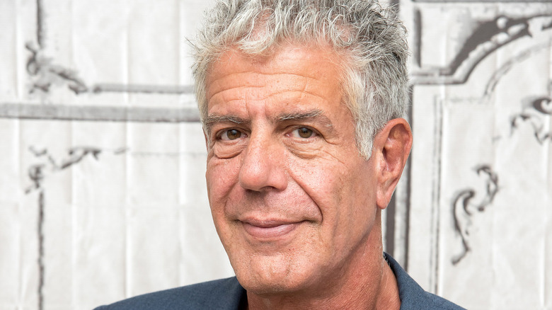 Anthony Bourdain looks forward with a soft smile