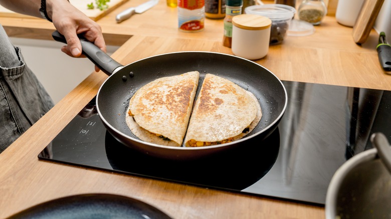 two quesadillas cooking in a pan