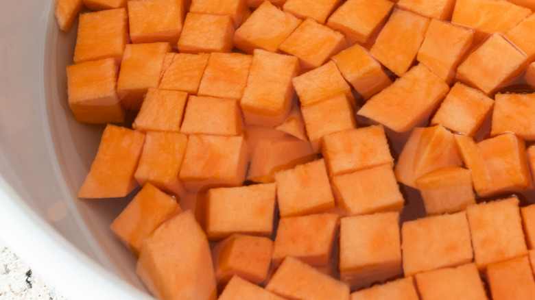 cubed sweet potatoes in bowl of water