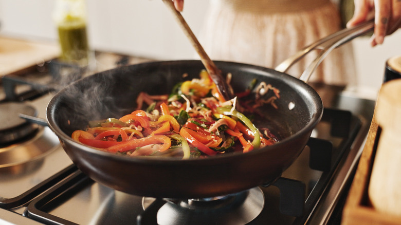 stir-frying food in a hot skillet