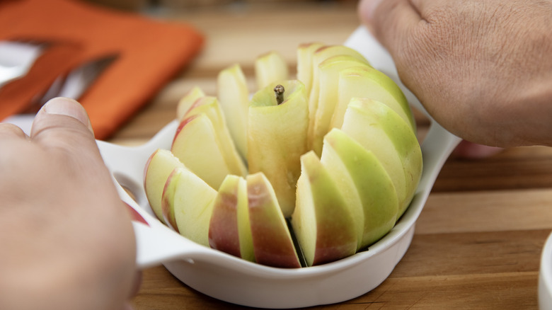 Hands using apple slicer