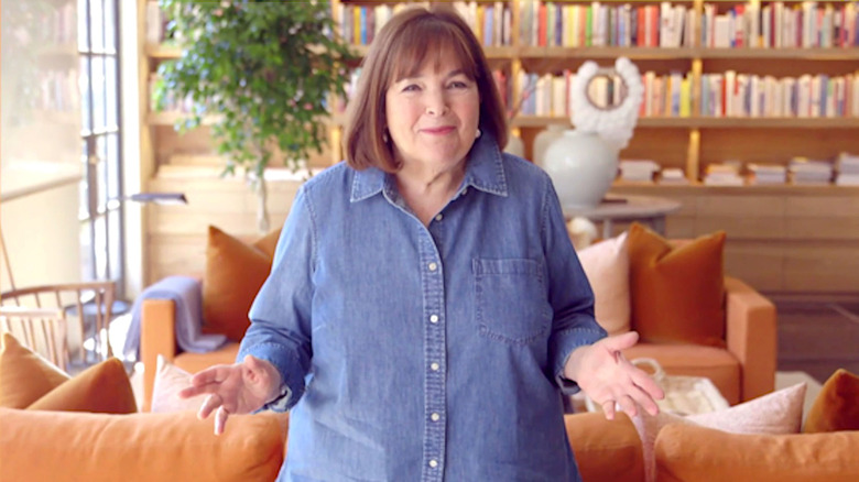 Ina Garten addressing the camera from a living room in front of bookshelves