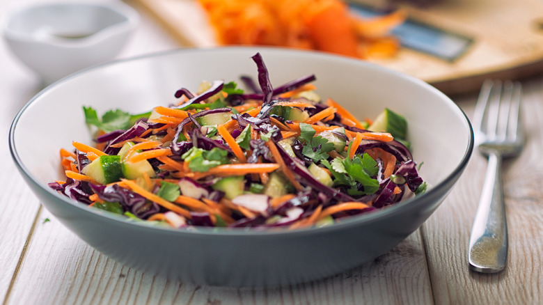 A bowl of coleslaw mix with a fork