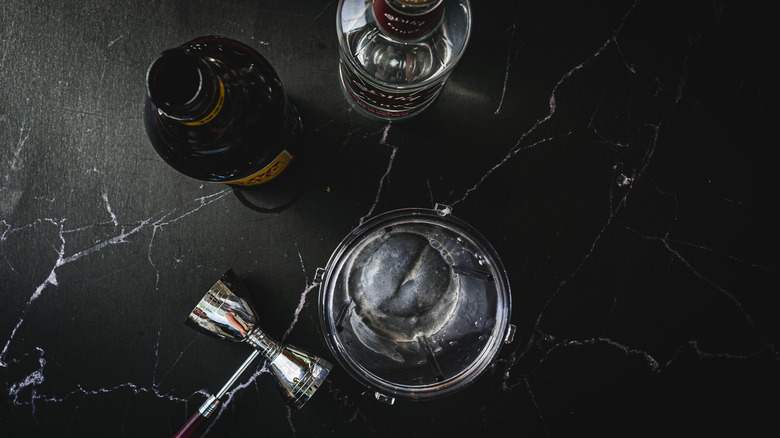 shaker next to bottles of spirits