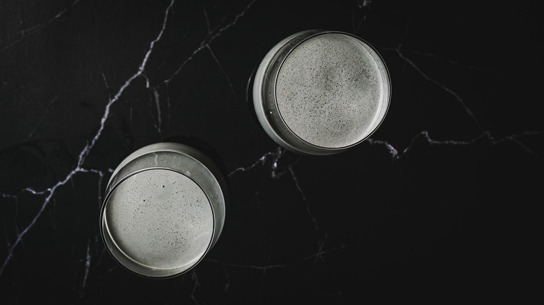 overhead of two glasses with foamy cocktail