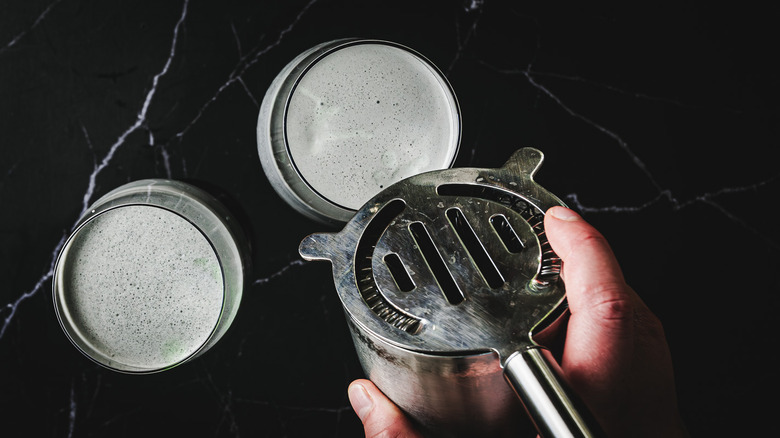 Pouring from strainer into glass