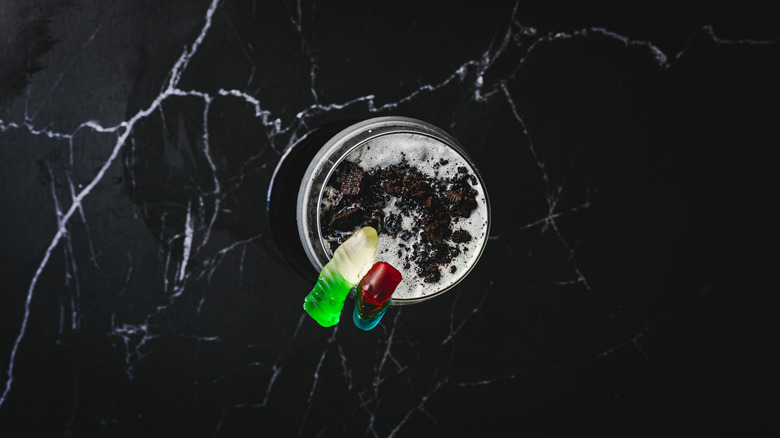 Cocktail with Oreo crumbs and gummy worms