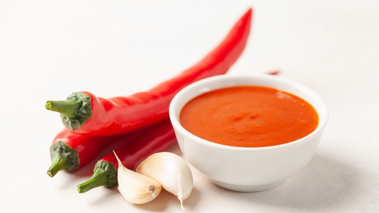 Peppers and bowl of hot sauce