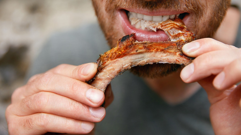 man eating pork rib